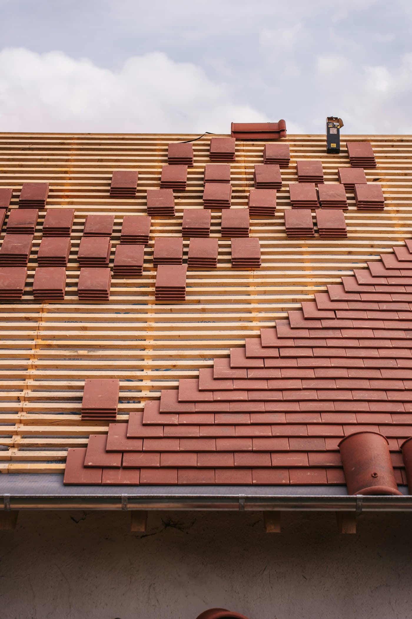 Roof tiles being installed over new timber battens
